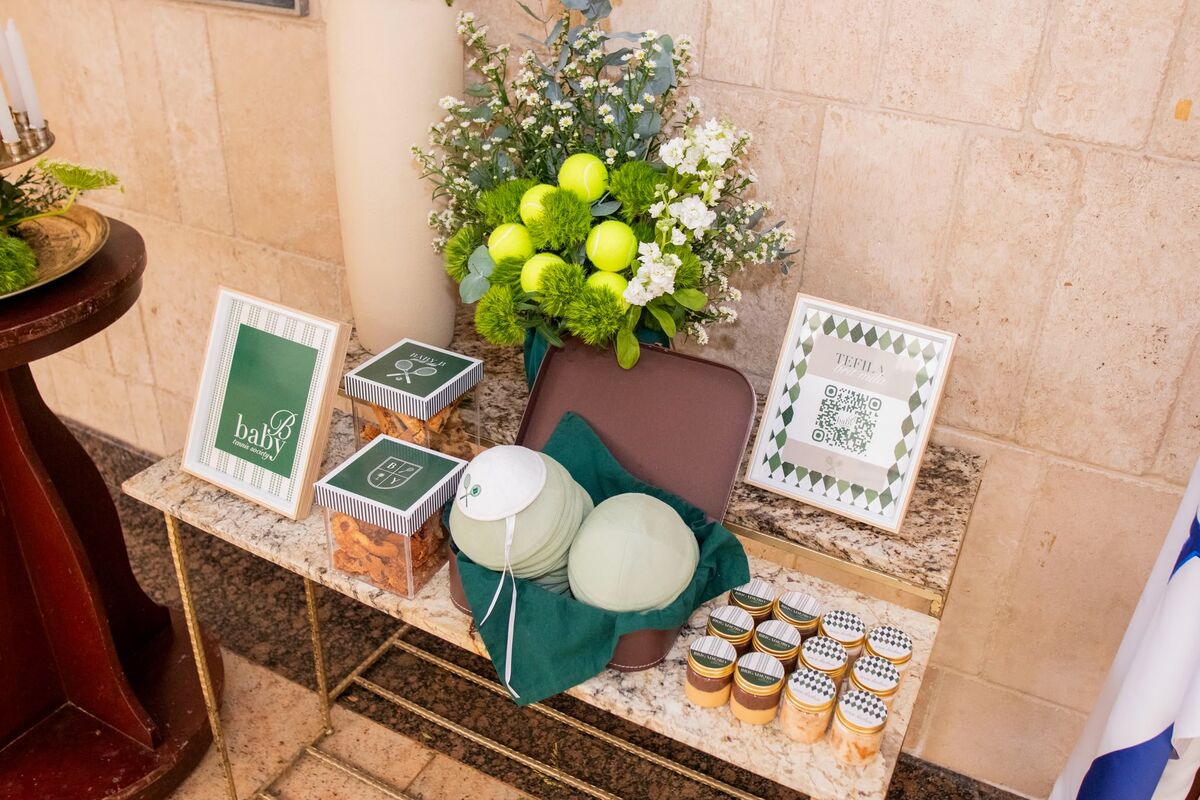 Mesa de bienvenida con kippot personalizadas en un evento judío